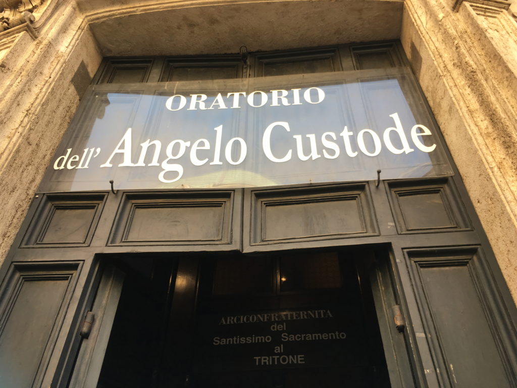 "Angelo Custode" means "Guardian Angel" in Italian. :)