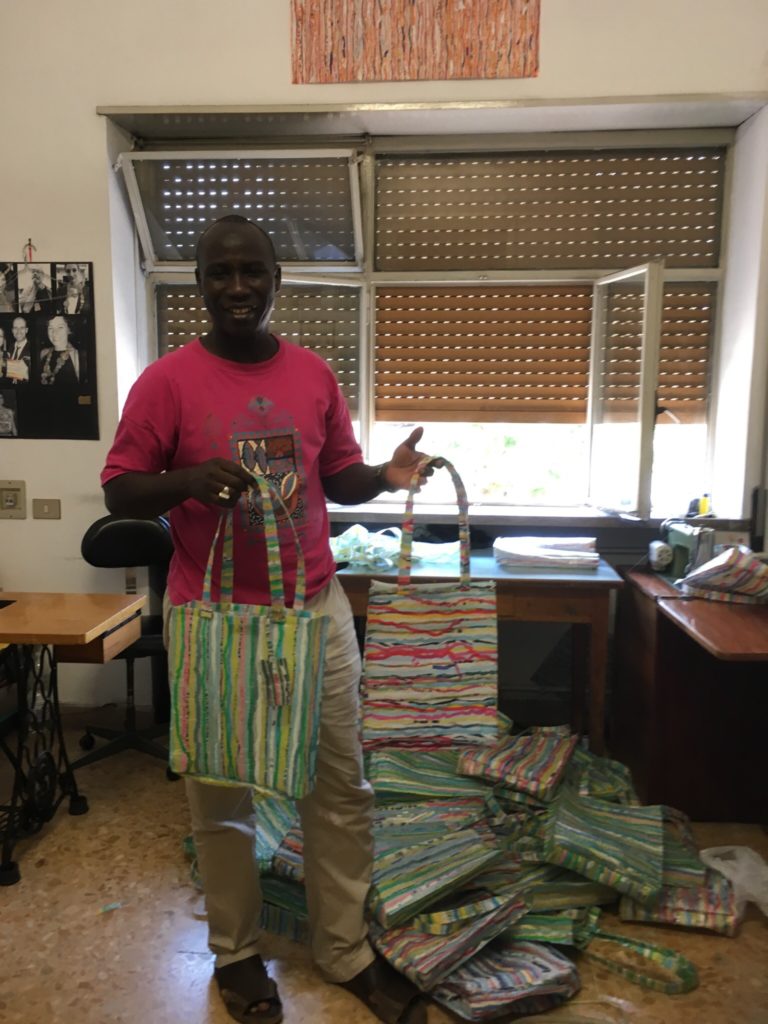 This refugee spoke Italian better than I do, but I still managed to ask if I could take a picture of him holding one of the bags he made. :)